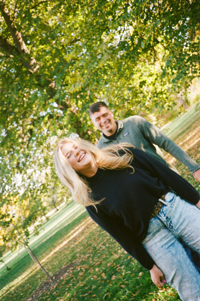 35mm film engagement session in Denver Colorado - couple laughing during golden hour
