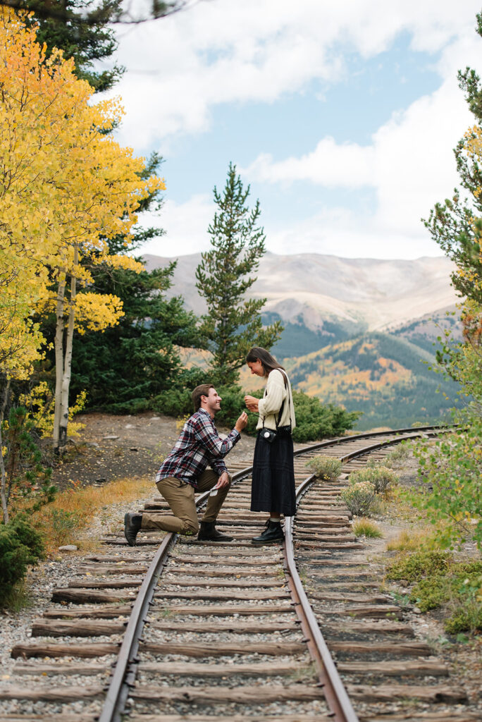 Couple celebrating their surprise engagement at Boreas Pass with  mountain views in Breckenridge, Colorado.