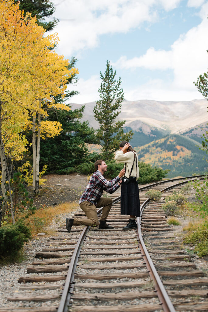 Couple celebrating their surprise engagement at Boreas Pass with  mountain views in Breckenridge, Colorado.