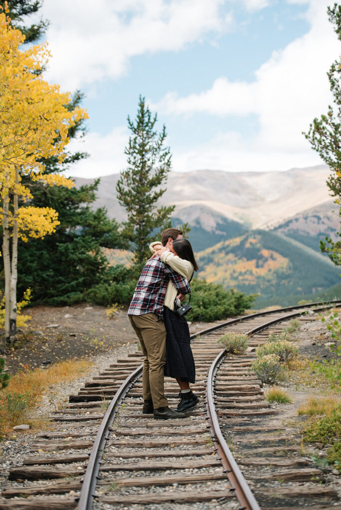 Couple celebrating their surprise engagement at Boreas Pass with  mountain views in Breckenridge, Colorado.