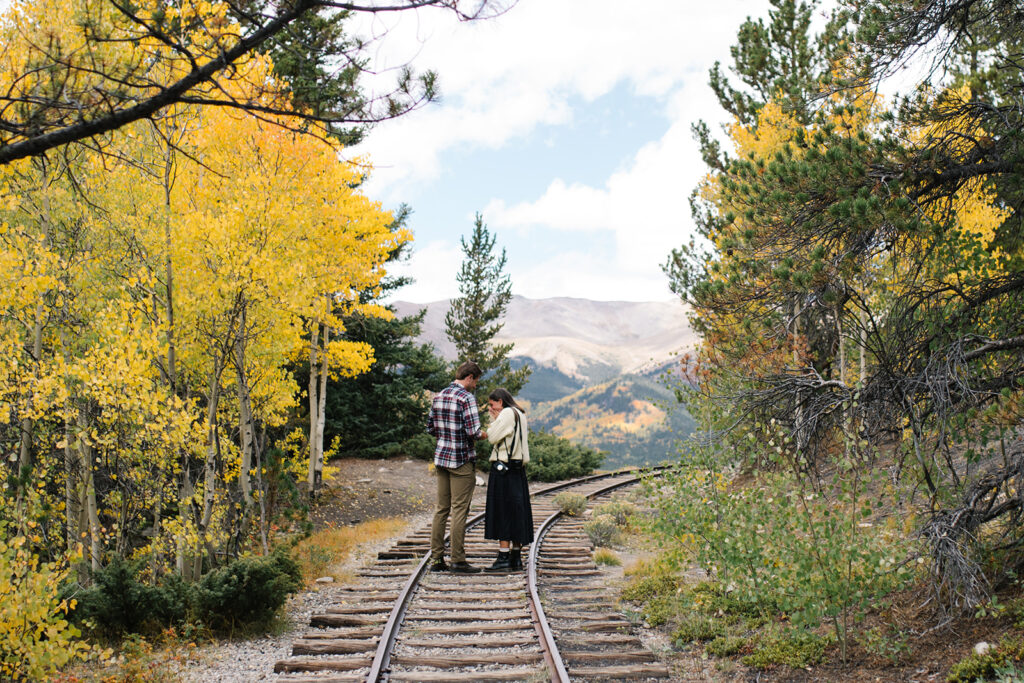 Couple celebrating their surprise engagement at Boreas Pass with  mountain views in Breckenridge, Colorado.