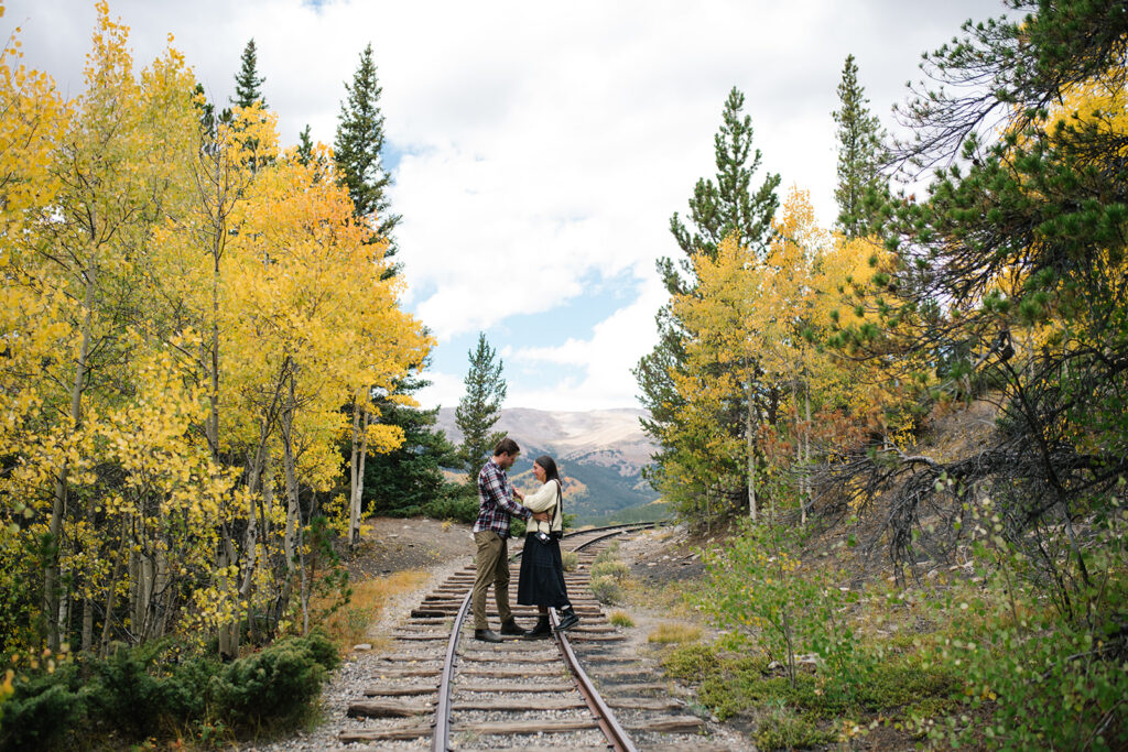 Couple celebrating their surprise engagement at Boreas Pass with  mountain views in Breckenridge, Colorado.