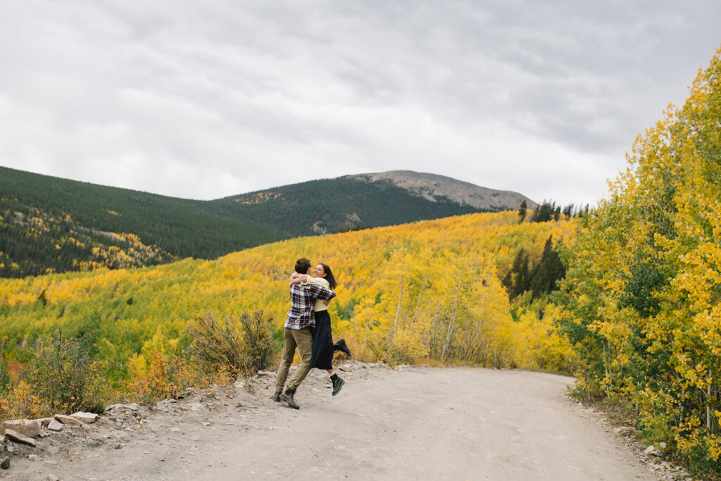 Romantic moment during a surprise proposal and engagement at Boreas Pass overlooking Breckenridg, Colorado.