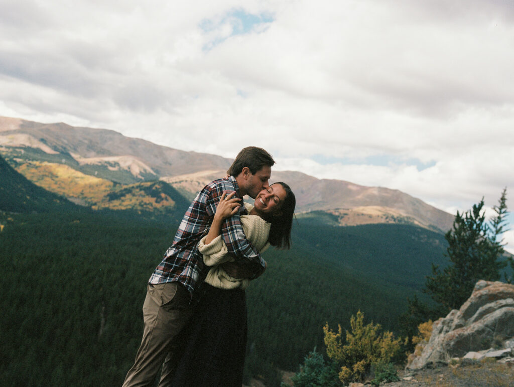 Couple celebrating their surprise engagement at Boreas Pass with  mountain views in Breckenridge, Colorado.