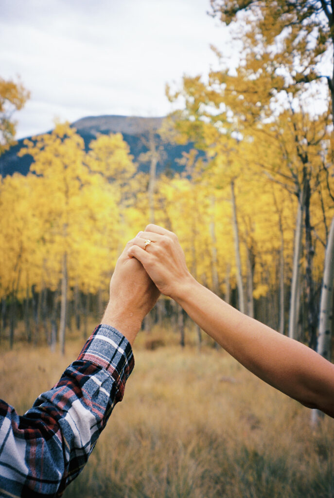 Romantic moment during a surprise proposal and engagement at Boreas Pass overlooking Breckenridg, Colorado.