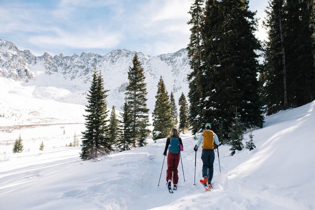 Winter engagement photos in Colorado with snow-covered mountains in the background.