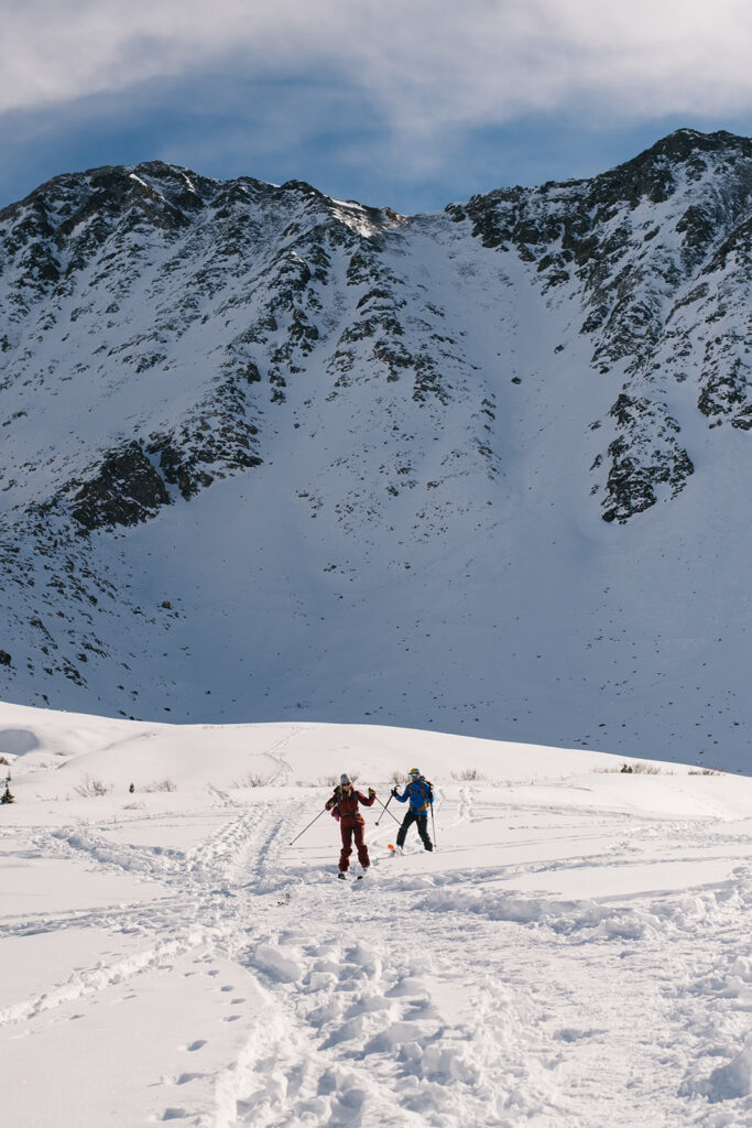 Winter engagement photos in Colorado with snow-covered mountains in the background.