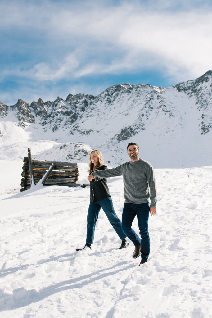 Winter engagement photos in Colorado with snow-covered mountains in the background.