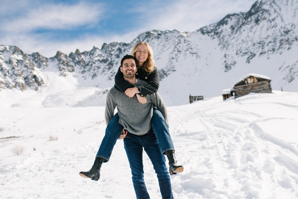 Winter engagement photos in Colorado with snow-covered mountains in the background.