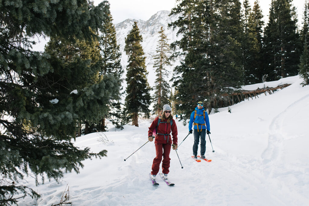 Winter engagement photos in Colorado with snow-covered mountains in the background.