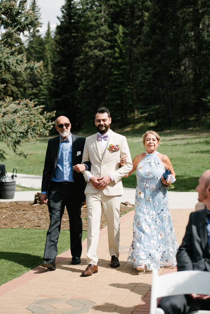 Latino ceremony at Wedgewood Mountain View Ranch in Pine, CO with mountain views and a rustic wooden arbor.