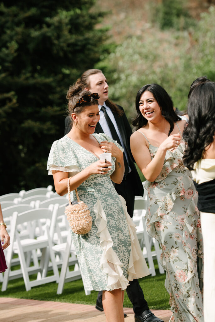 Guests relaxing outside during cocktail hour at Wedgewood Mountain View Ranch, surrounded by Colorado pine trees.