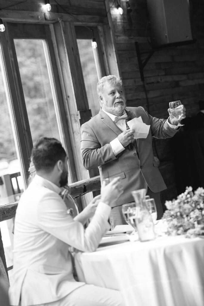 Bride and groom's during speeches  inside Wedgewood Mountain View Ranch’s lodge-style reception space.