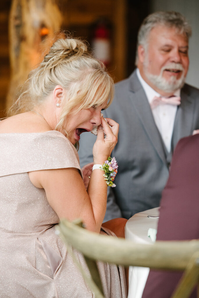 Bride and groom's during speeches  inside Wedgewood Mountain View Ranch’s lodge-style reception space.