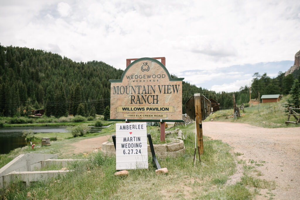 Outdoor wedding ceremony at Wedgewood Mountain View Ranch in Pine, CO with mountain views and a rustic wooden arbor.