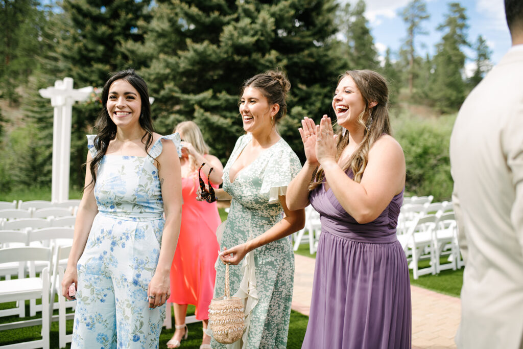 Guests relaxing outside during cocktail hour at Wedgewood Mountain View Ranch, surrounded by Colorado pine trees.