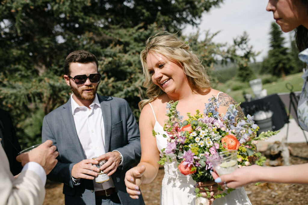 Guests relaxing outside during cocktail hour at Wedgewood Mountain View Ranch, surrounded by Colorado pine trees.