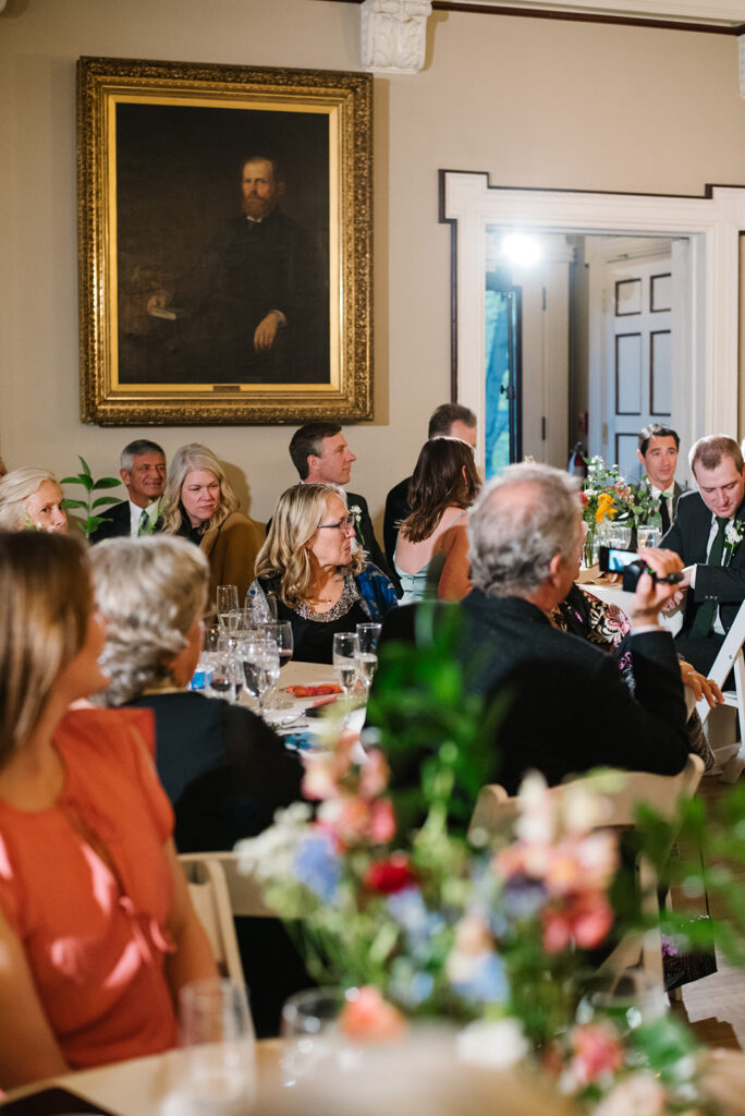 Candlelit wedding reception inside Grant Humphreys Mansion with long dinner tables

