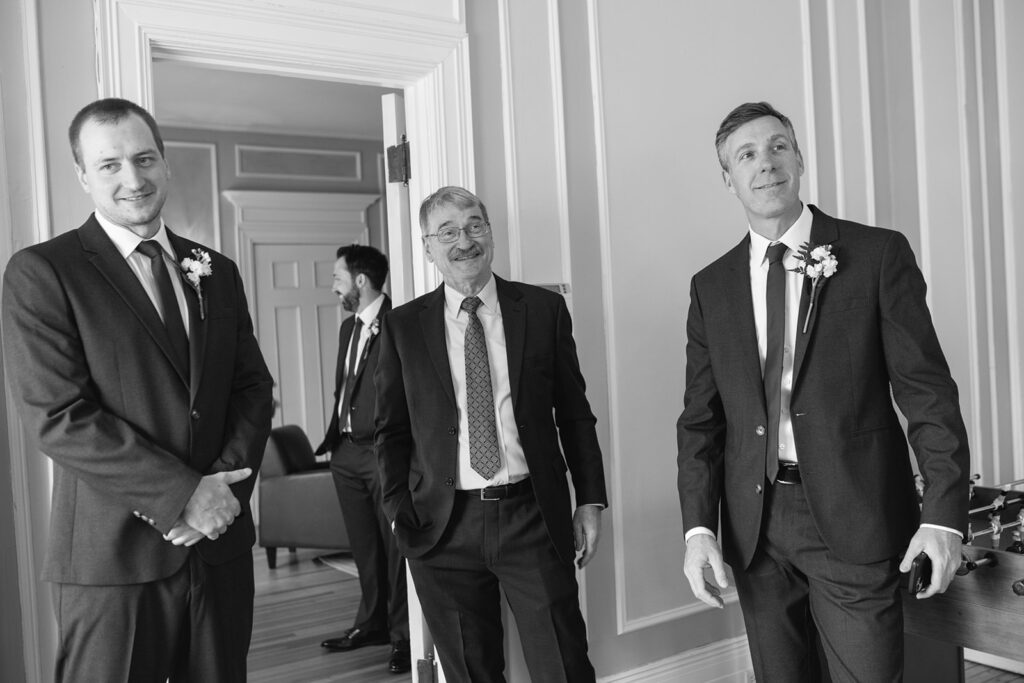 Groom tying tie in upstairs room of Grant Humphreys Mansion before wedding ceremony
