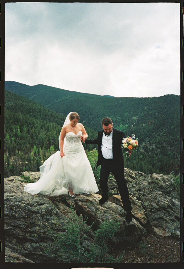 Bride and groom standing on ceremony deck at North Star Gatherings in Idaho Springs with mountain views behind them.