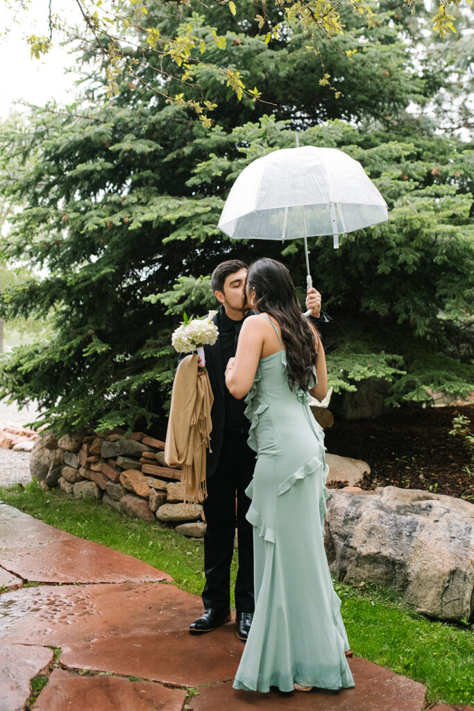 Rainy spring Greenbriar Inn wedding ceremony with guests under umbrellas.