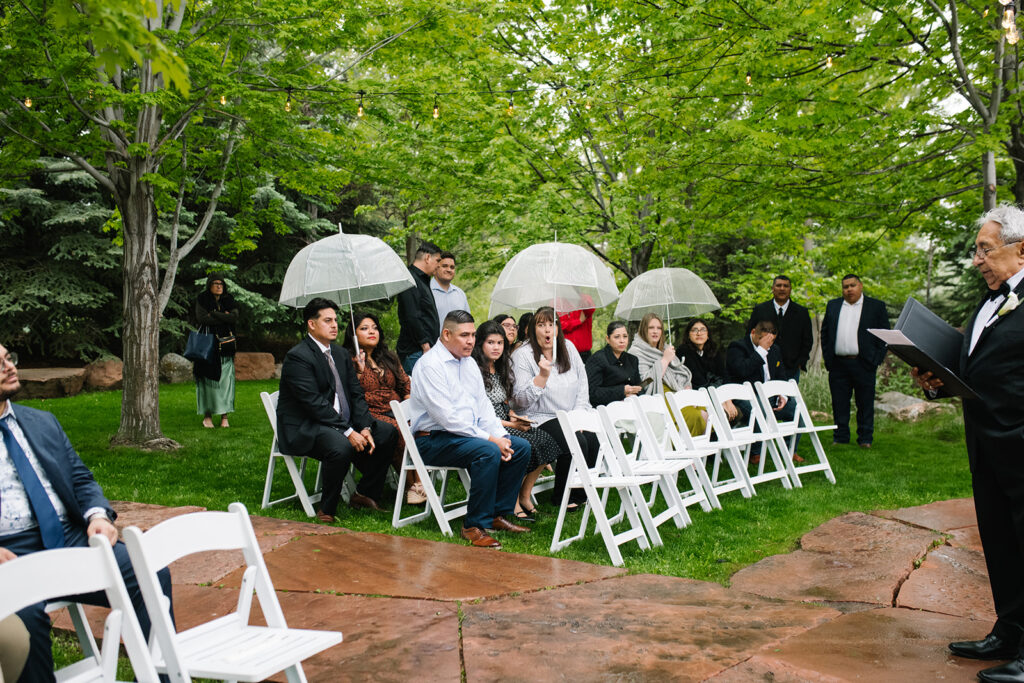 Rainy spring Greenbriar Inn wedding ceremony with guests under umbrellas.