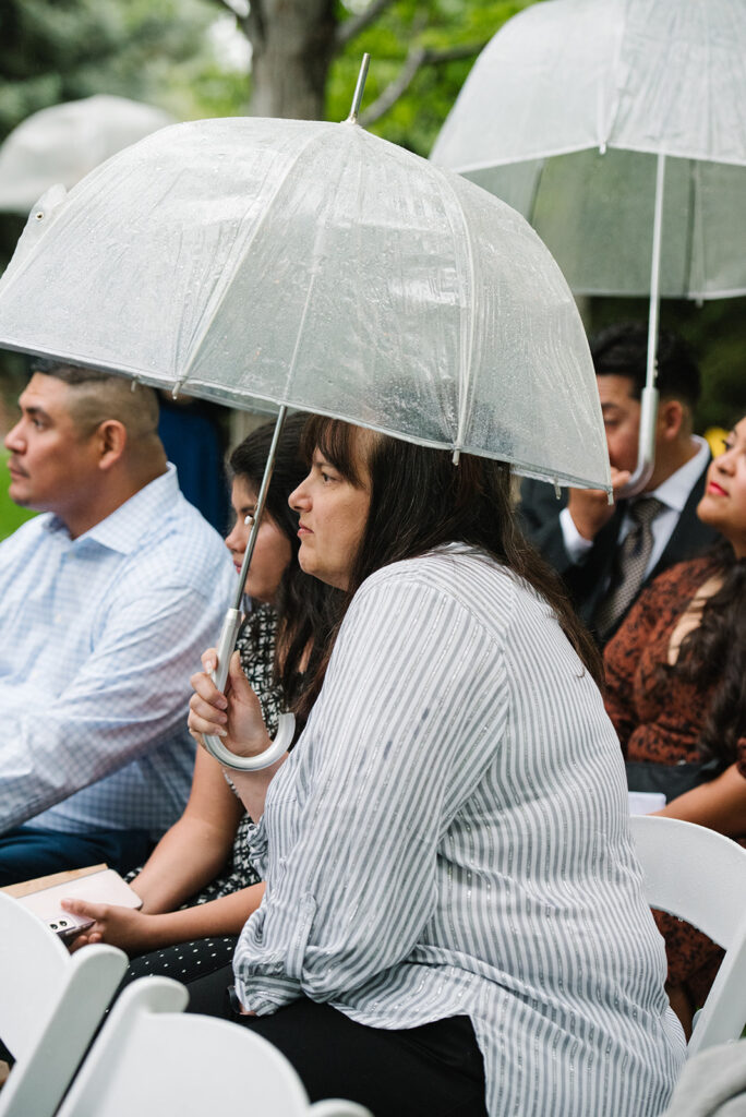 Rainy spring Greenbriar Inn wedding ceremony with guests under umbrellas.