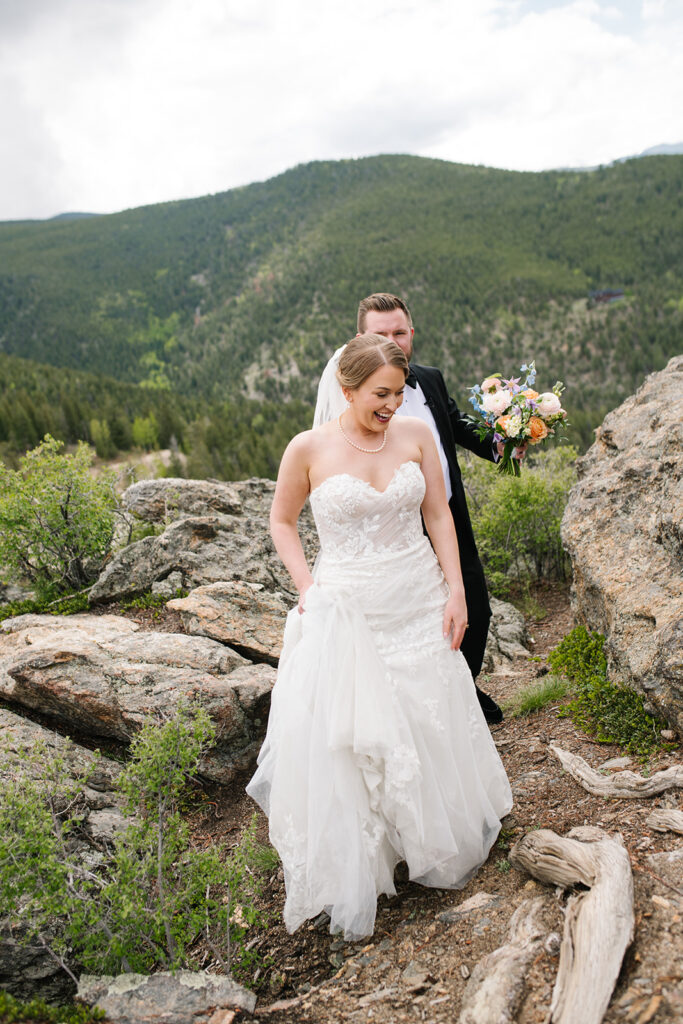 Bride and groom standing on ceremony deck at North Star Gatherings in Idaho Springs with mountain views behind them.
