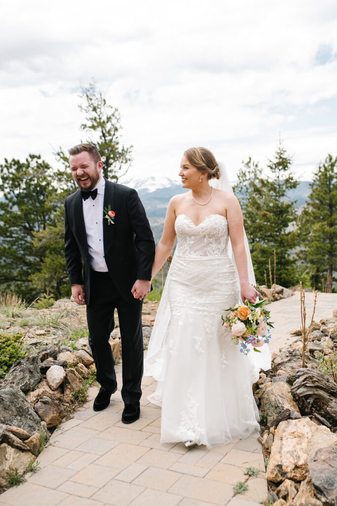 Bride and groom standing on ceremony deck at North Star Gatherings in Idaho Springs with mountain views behind them.