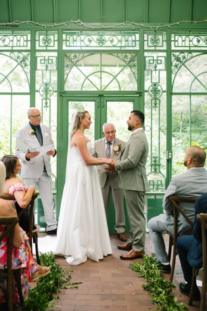 intimate and candid moments of guests at a ceremony taking place at the Mosaic Solarium in the Denver Botanic Gardens