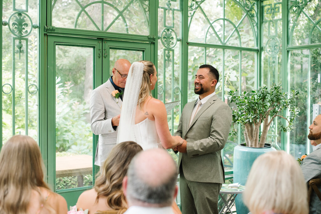 A ceremony taking place at the Mosaic Solarium in the Denver Botanic Gardens by a documentary wedding photographer